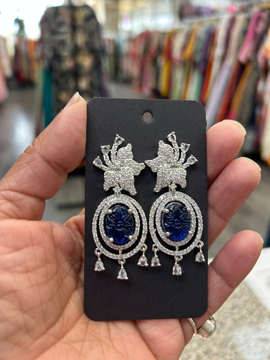 Kurti Connection USA oval deep blue gemstone dangle earrings with cubic zirconia halo and floral top.