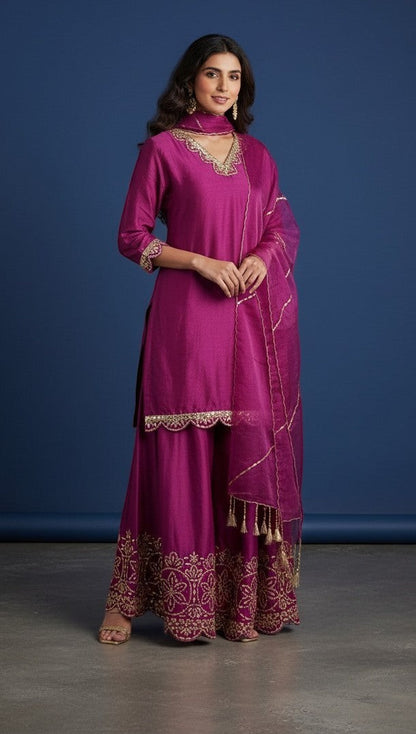 Kurti Connection USA magenta silk sharara suit with gold embroidery on neckline, sleeves, and hem. Includes dupatta with tassels.